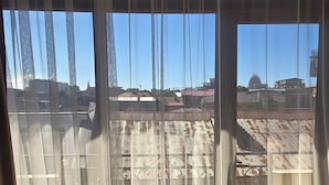 A room with large windows, a view of the cityscape, and a patterned floor. - Mahali Hotel (Batumi)