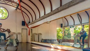 Una habitación con un espejo grande, un ventanal circular y un techo con vigas de madera.