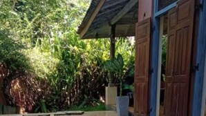 Una piscina con un deck de madera y una zona cubierta con persianas azules.