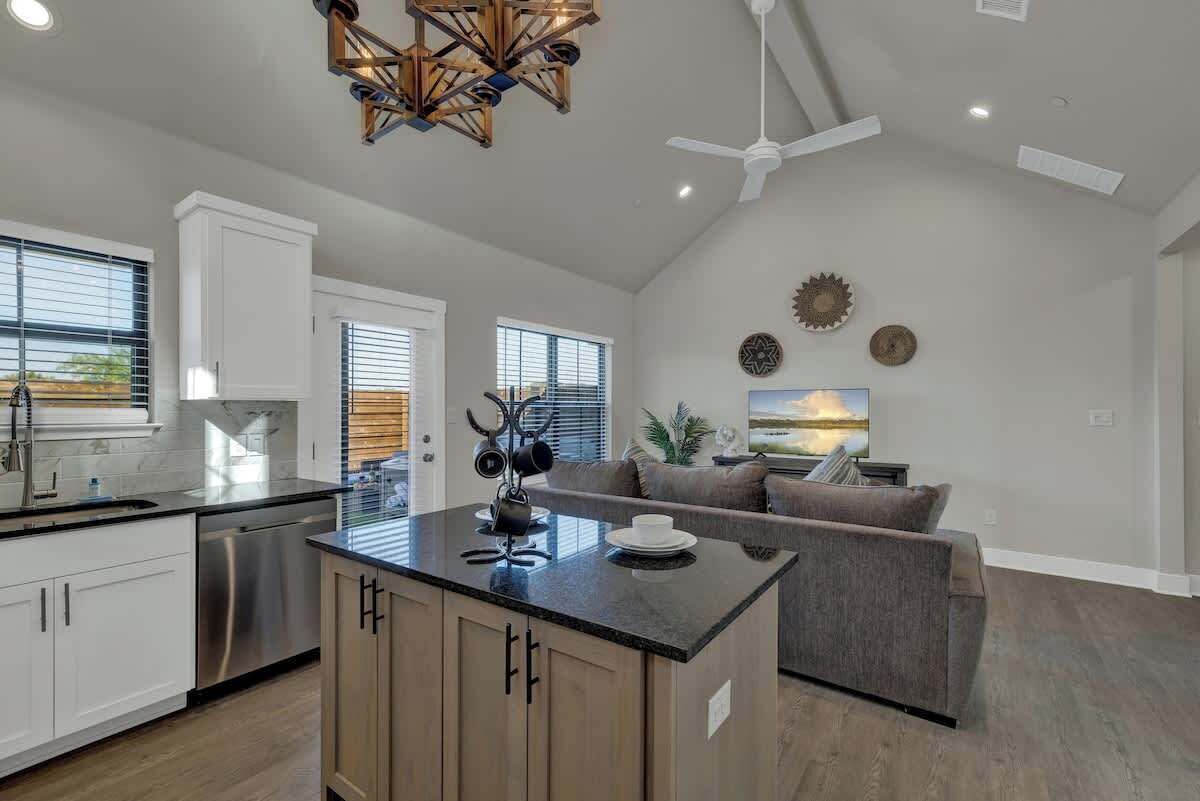 A modern kitchen with a central island, built-in appliances, and a dining area with a sofa.