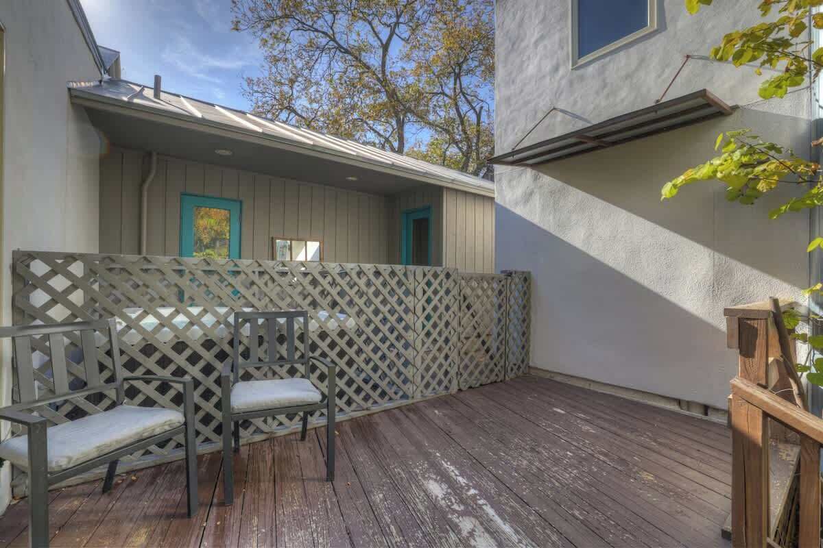 A wooden deck with two chairs and a lattice fence.