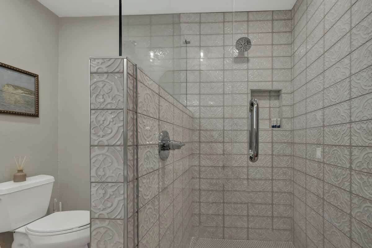 Un bagno con doccia, WC e una parete decorativa.