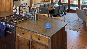 Una cocina amplia con una isla central, vigas de madera y ventanas grandes.