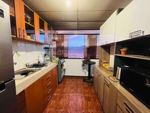 Enjoy cooking in this kitchen with a sink, stove, and ample countertop space.