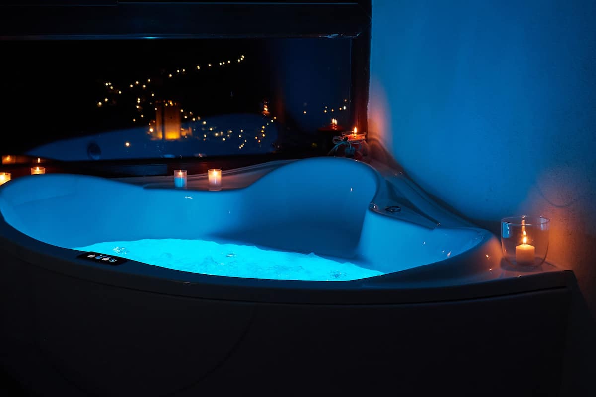 A hot tub with candles around it.