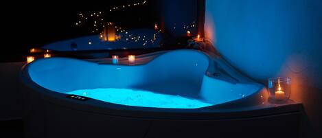 A hot tub with candles around it.