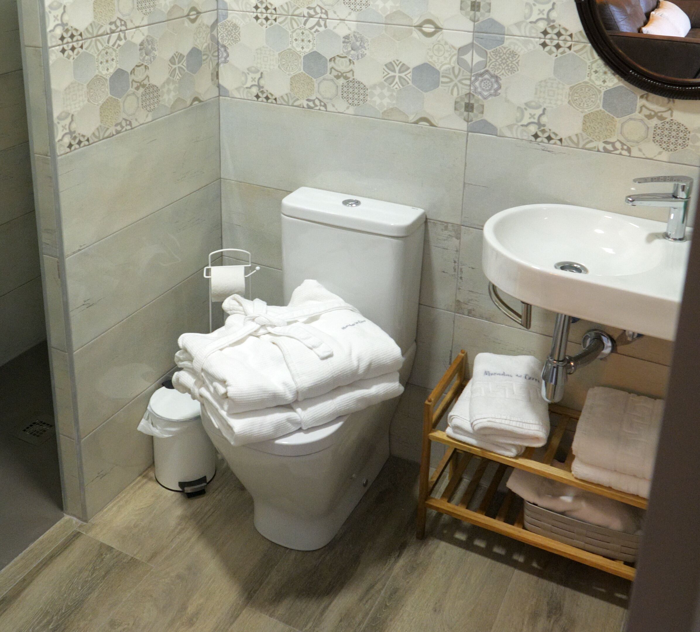 A bathroom with a toilet, sink, and a towel rack.
