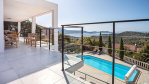 A modern outdoor pool area with a clear view of the sea and hills. - Spacious villa w/ exceptional sea-view, pool & petanque ground _ 5 mn from beach (Lumio)