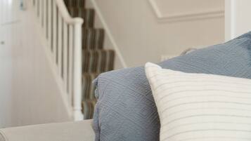 A staircase with a white railing and striped carpet.