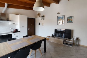 Een moderne keuken met een eethoek, een televisie en kunst aan de muur.