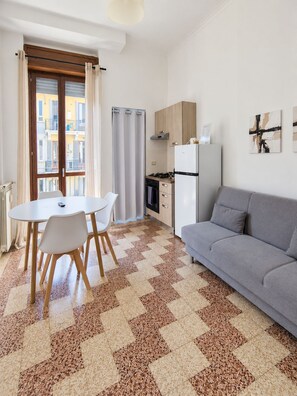 A compact living space with a dining area, kitchenette, and a sofa. - BIG Suite Goldoni [Duomo-M4 Lin Airport] (Milan)