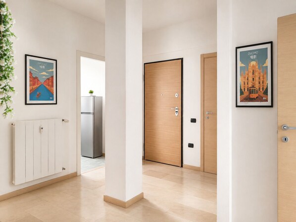 A hallway with a radiator, a door, and a framed picture on the wall.