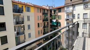 Un immeuble résidentiel à plusieurs étages, doté de balcons, d’une antenne visible et surplombant un ciel dégagé.