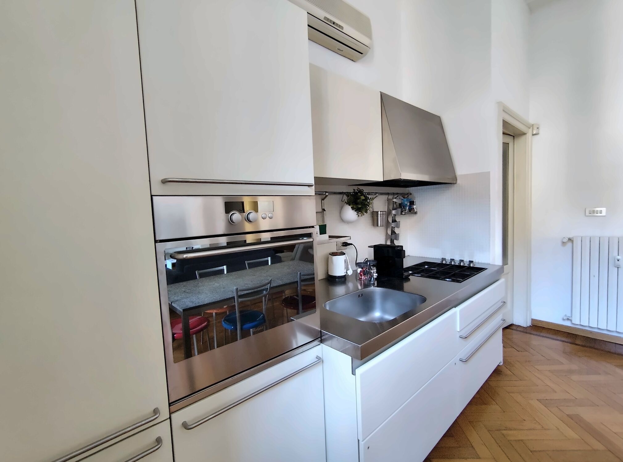 Une cuisine moderne équipée d’appareils électroménagers en acier inoxydable, d’un four encastré, d’une cuisinière et d’un évier.