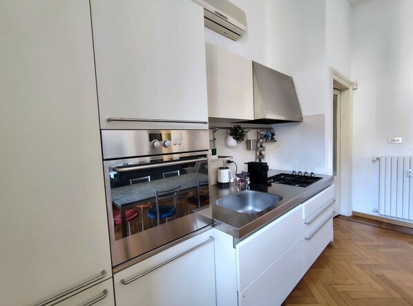 A modern kitchen with stainless steel appliances, a built-in oven, a stove, and a sink.