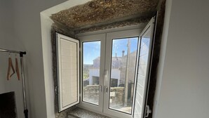Ein Zimmer mit kleinem Fenster, Heizkörper und Tür.