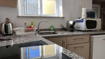 Efficient kitchen with granite countertop, stainless steel sink, and ample cabinetry.