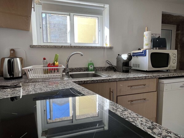 Efficient kitchen with granite countertop, stainless steel sink, and ample cabinetry.