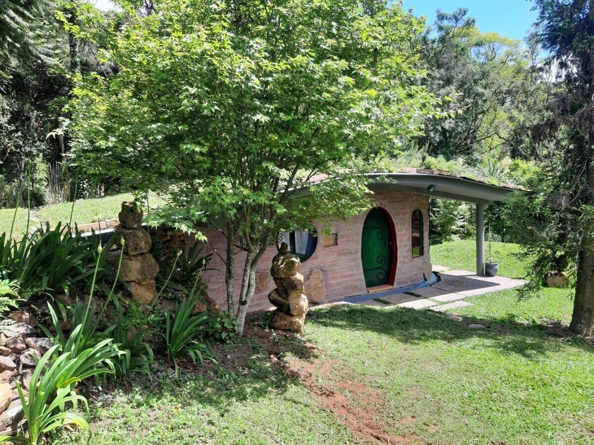 A small brick building with a green door and a covered porch.