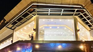 Ein Gebäude mit moderner Architektur, das einen markanten Eingang mit Glasfassade und ein Schild mit der Aufschrift "kerolstory" zeigt.