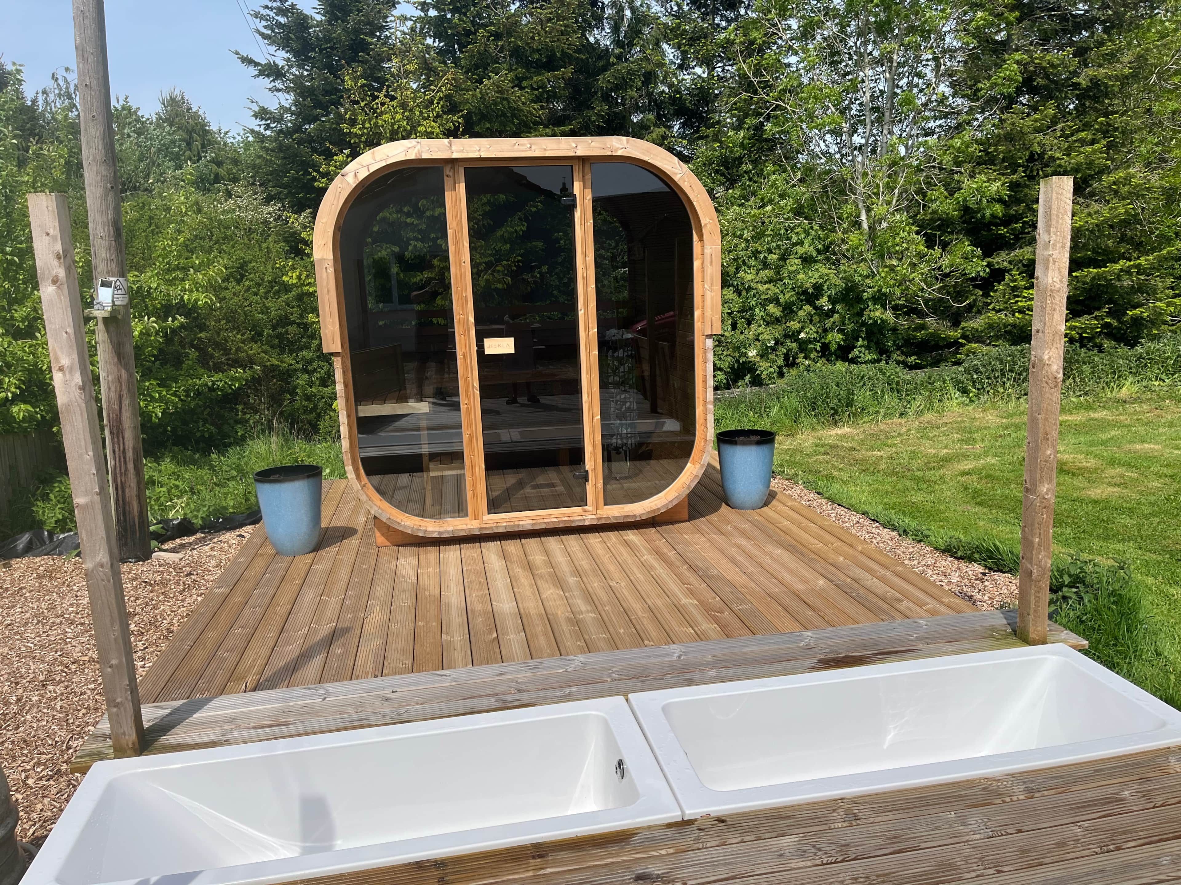 A wooden deck with a glass-enclosed structure, two sinks, and a sign indicating a private area.
