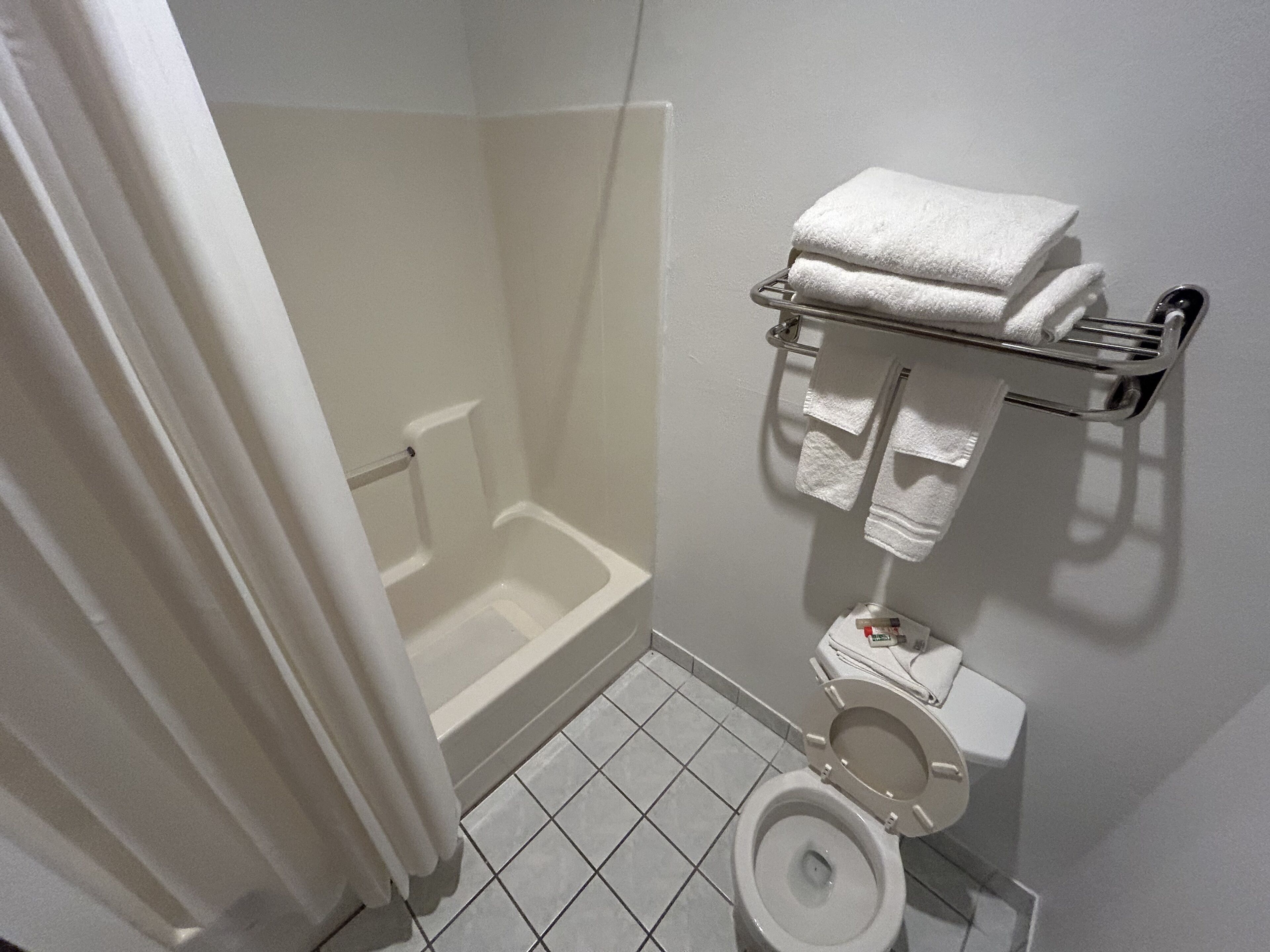 A bathroom with a bathtub, toilet, and towel rack.