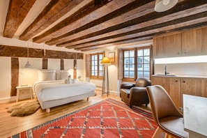 Cozy retreat with a large bed, wooden cabinets, and a desk by the window.