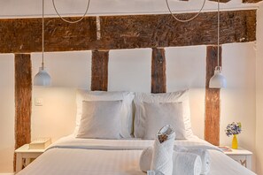 Cozy retreat with a large bed, bedside tables, and a vase with fresh flowers.