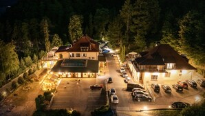 A hotel with a parking lot, multiple buildings, and a forested area. - Hotel Łaziska (Czchow)