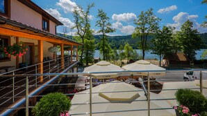 A lakeside hotel with outdoor seating and a view of the lake. - Hotel Łaziska (Czchow)