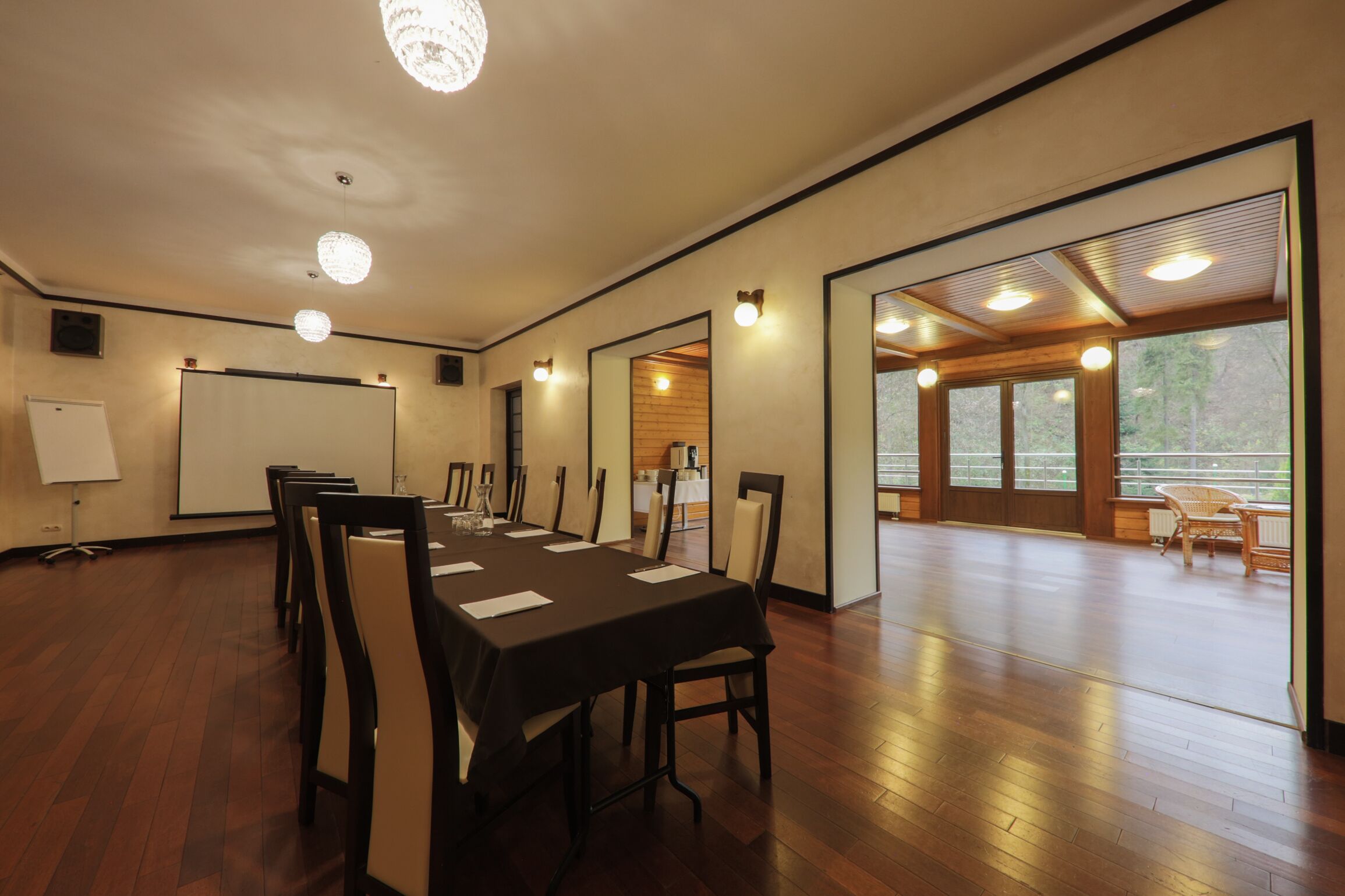 A conference room with a long table, chairs, a whiteboard, and large windows.