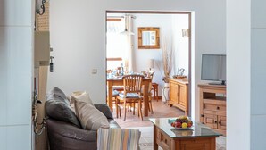 Una sala de estar con sofá, una mesa de centro y un comedor con sillas y una mesa.