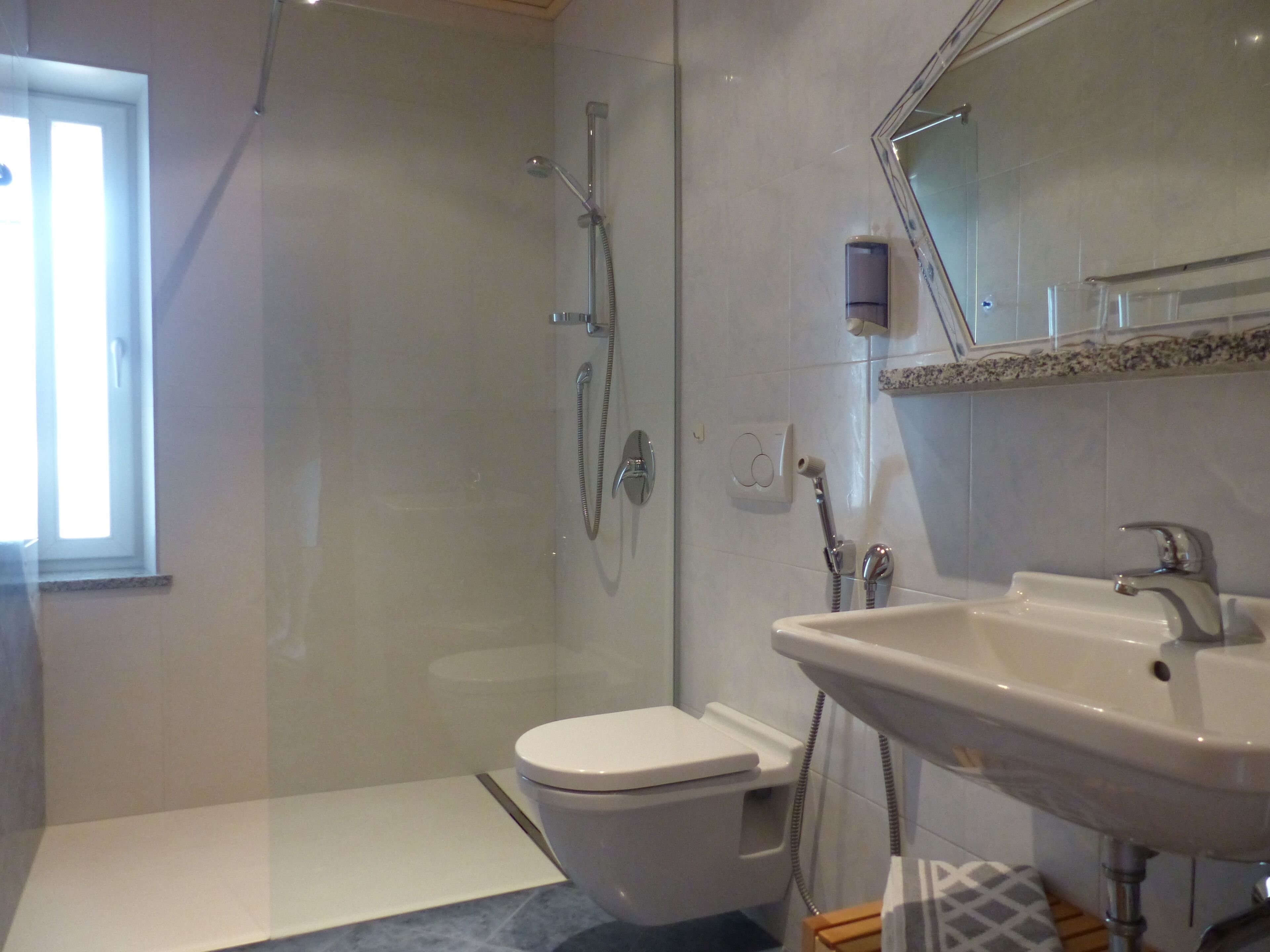 Une salle de bain moderne équipée d’une douche, de toilettes et d’un lavabo.