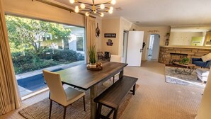 Un coin repas avec une table en bois, deux chaises, un banc et un panneau indiquant un bar à café.