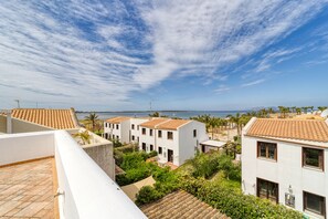 A coastal residential area with terracotta-tiled roofs, white buildings, and a view of the sea. - Stagnone Wine House (Marsala)