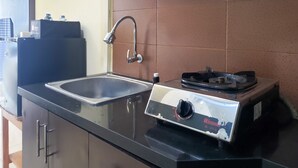 Une cuisine équipée d’un évier, d’une cuisinière à gaz Rinnai et d’un chauffe-eau.