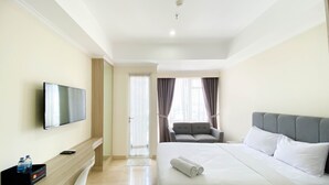 Ein Hotelzimmer mit Bett, Fernseher, Schreibtisch und Stuhl.