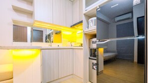 Eine kompakte Küche mit integriertem Kühlschrank, einer Mikrowelle und einem Herd.