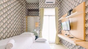 Une chambre d’hôtel équipée d’un lit, d’une télévision et d’un bureau avec un ordinateur.