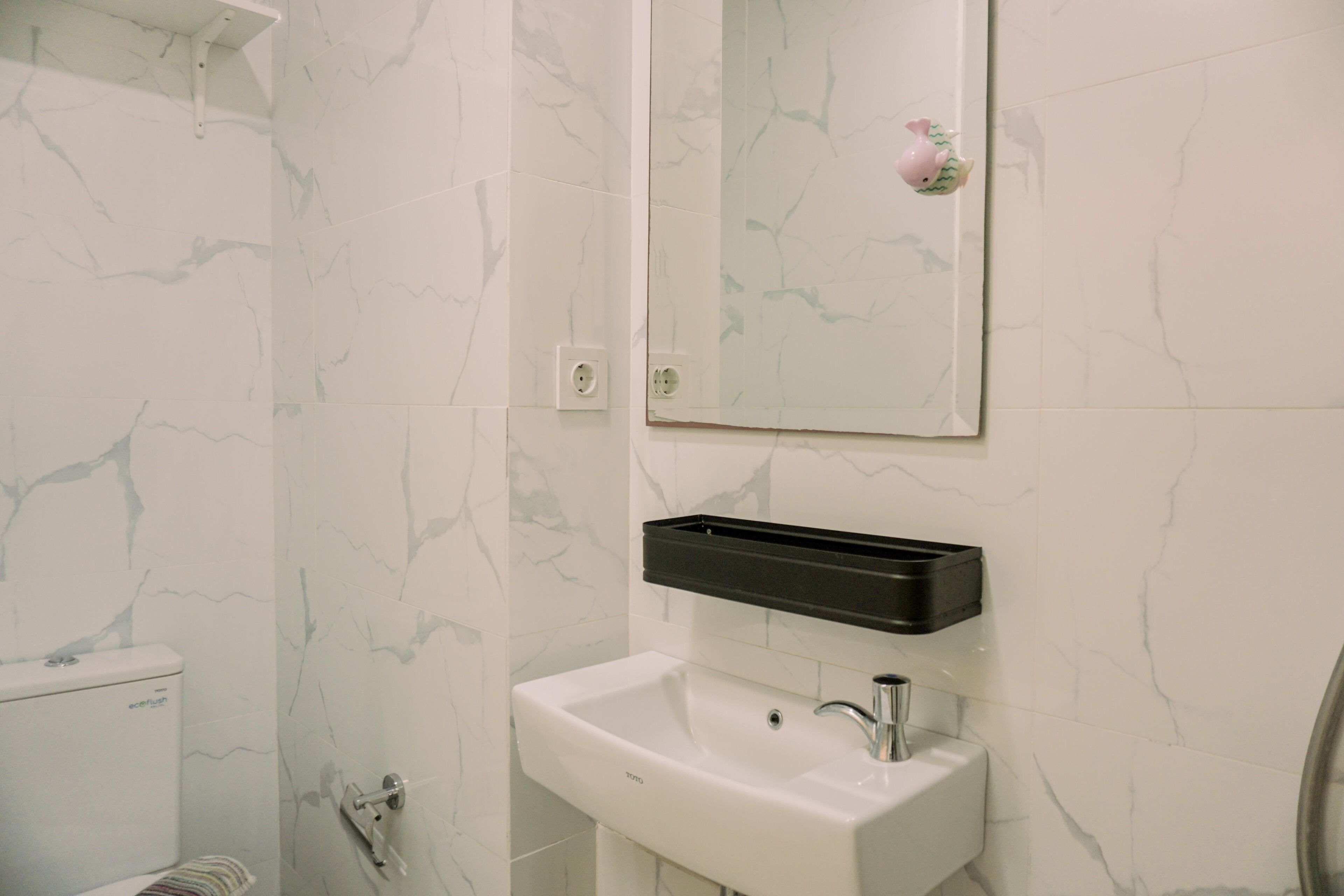 Ein Badezimmer mit Toilette, Waschbecken und Spiegel.