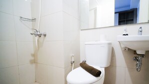 A bathroom with a toilet, a shower, and a sink. - Simple And Cozy Studio At Tanglin Supermall Mansion Apartment (Surabaya)