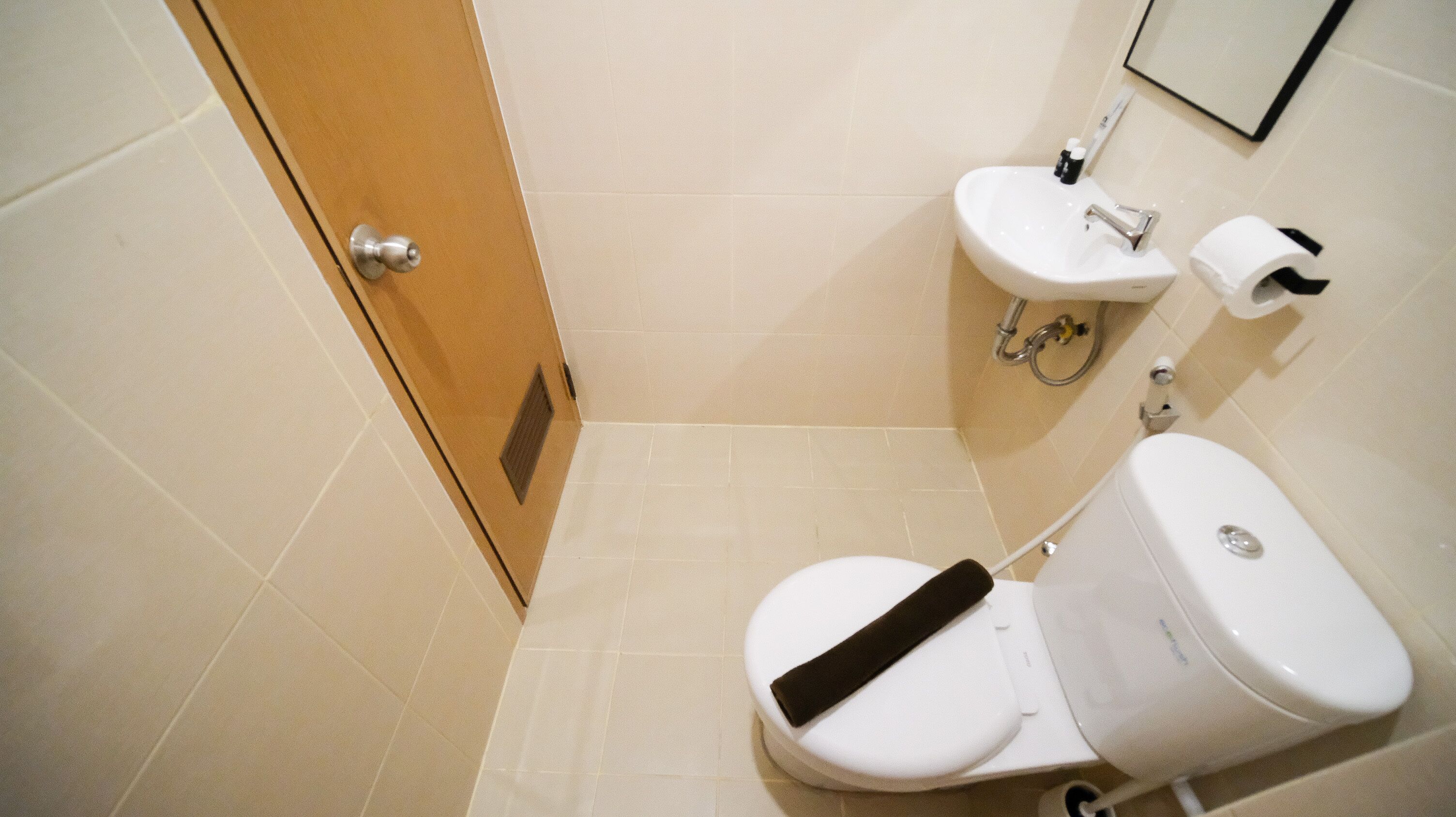Une salle de bain avec des toilettes, un lavabo et une porte.