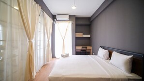 Una habitación de hotel moderna con una cama grande, un escritorio y una silla.