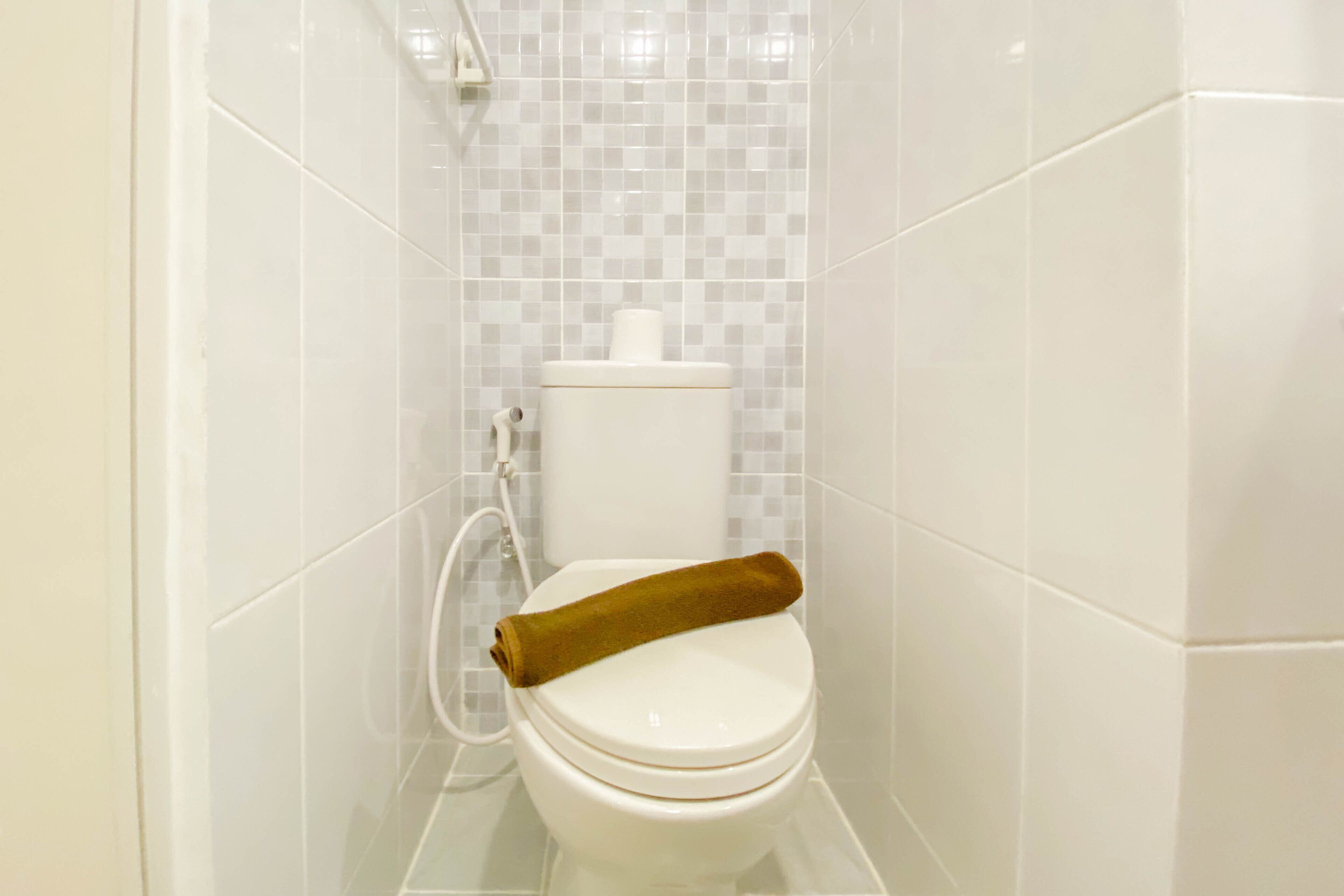 Un baño con inodoro, toalla y ducha.