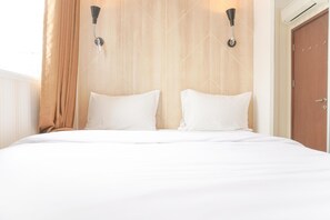 Una habitación de hotel con una cama grande, dos lámparas de pared y un cabecero de madera.