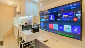 Una cocina moderna con un televisor de pantalla plana grande montado en la pared, mostrando diversas aplicaciones de transmisión.
