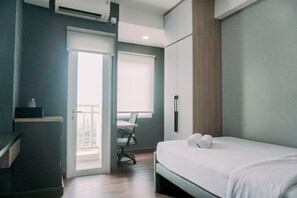 Relax in a serene space with a comfortable bed, desk, and natural views.