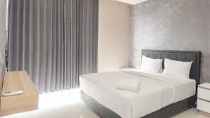 Ein modernes Hotelzimmer mit einem großen Bett, einem Nachttisch und einem Fenster mit Vorhängen.