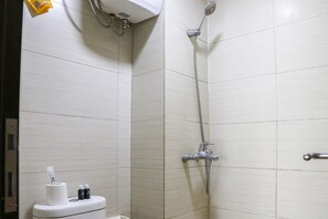 Ein Badezimmer mit Toilette, Dusche und Handtuchspender.