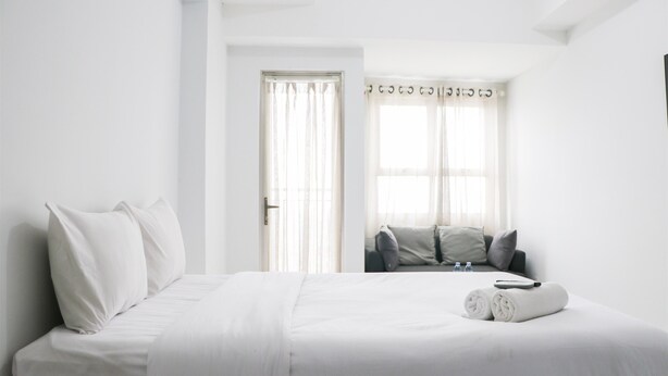 Een hotelkamer met een groot bed, een raam met gordijnen en uitzicht op buiten.